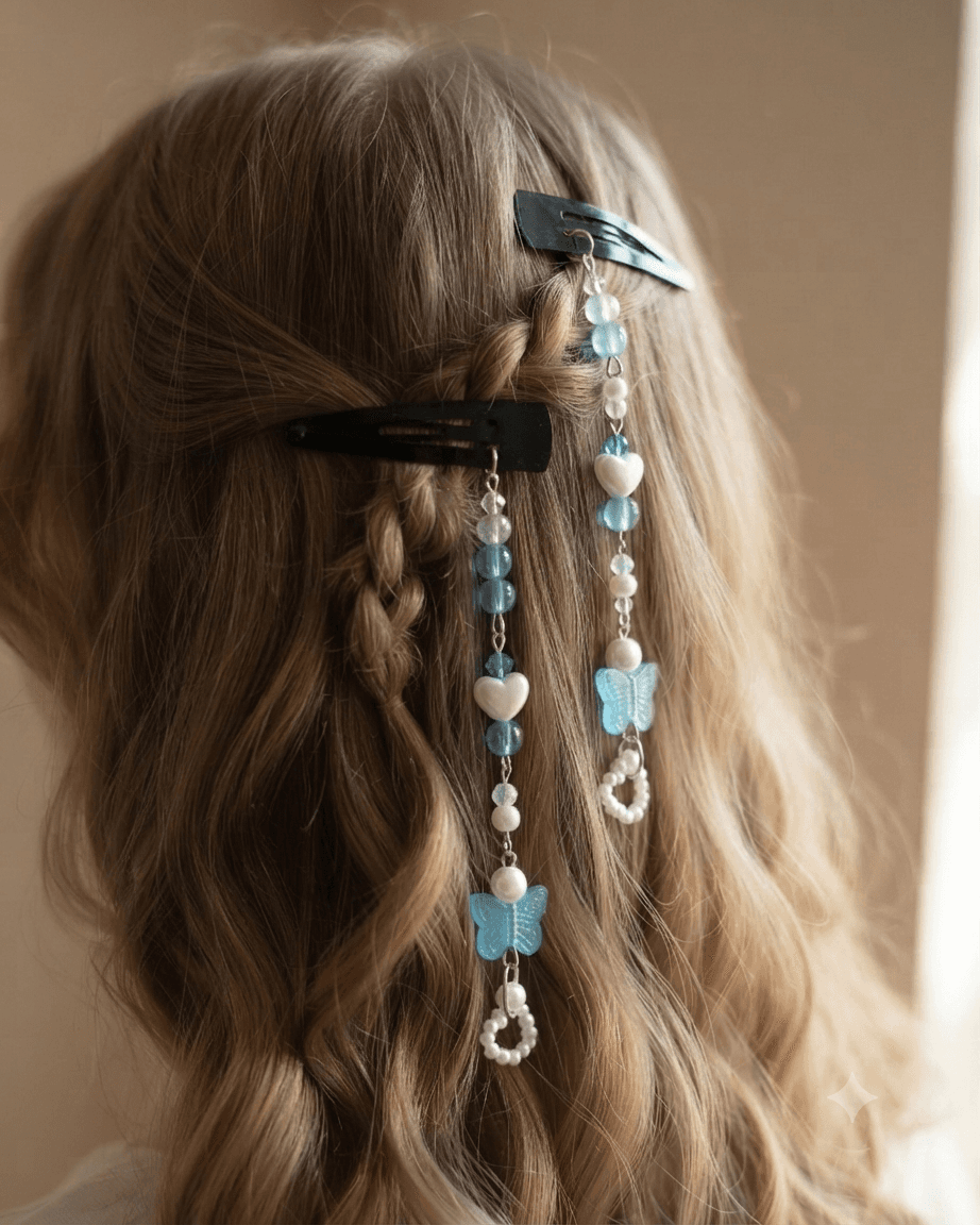 Woman wearing matching black hair clips with aqua-blue butterfly beads, white heart details and long beaded dangles in her hair.