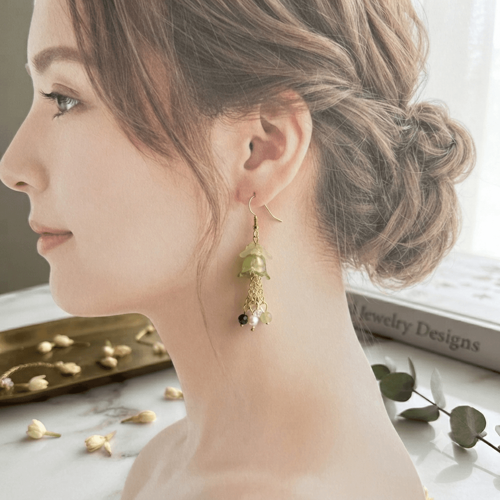 Woman wearing a handmade green floral dangle earring with a flower-shaped bead, gold-tone chains and small bead accents.