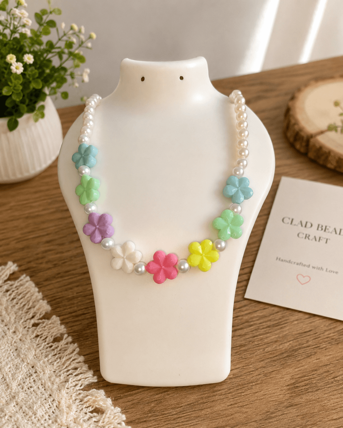 Pastel flower bead necklace with colourful sky blue, mint green, lavender, white, pink and yellow flowers on a pearl-look artificial bead strand.