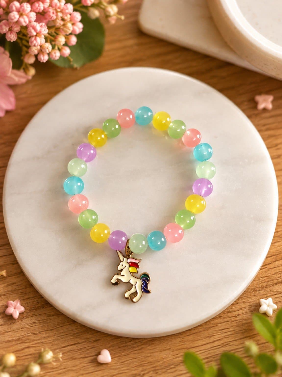Multicolour pastel round-bead stretch bracelet with a white unicorn charm and colourful mane and tail.