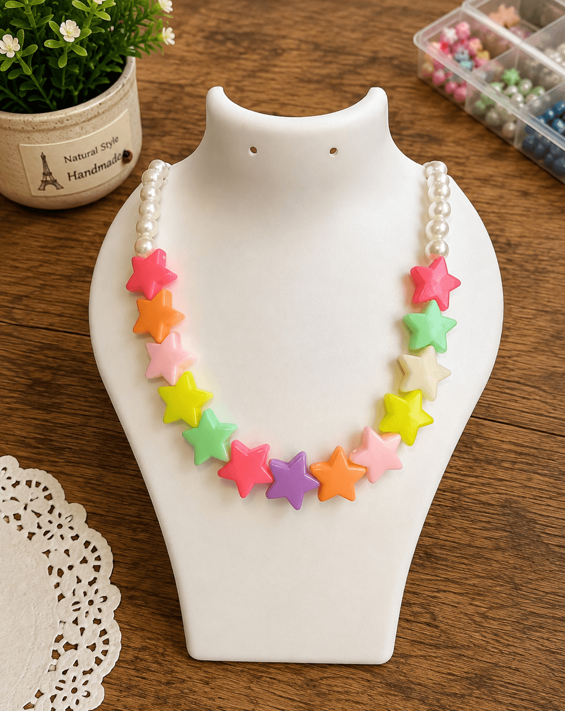 Rainbow star bead necklace with hot pink, orange, light pink, yellow, mint green, purple, green and cream star beads on a round pearl-look artificial bead strand.