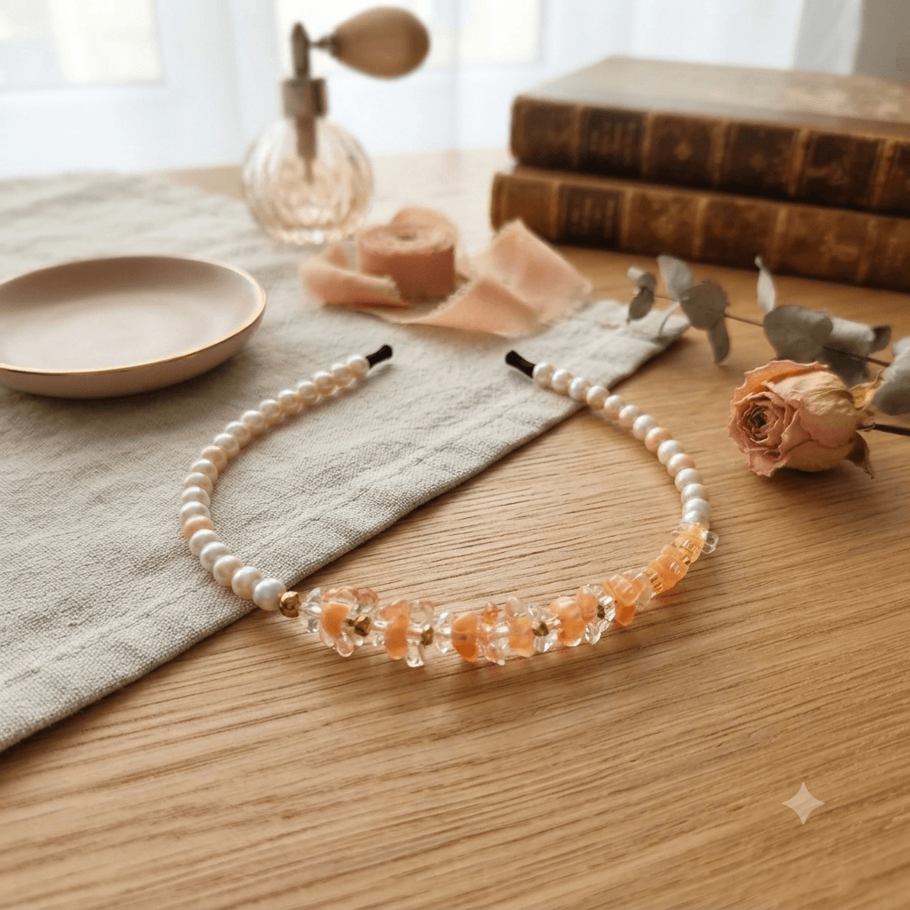 Peach pearl-look beaded headband with decorative peach and clear beads displayed on a wooden surface
