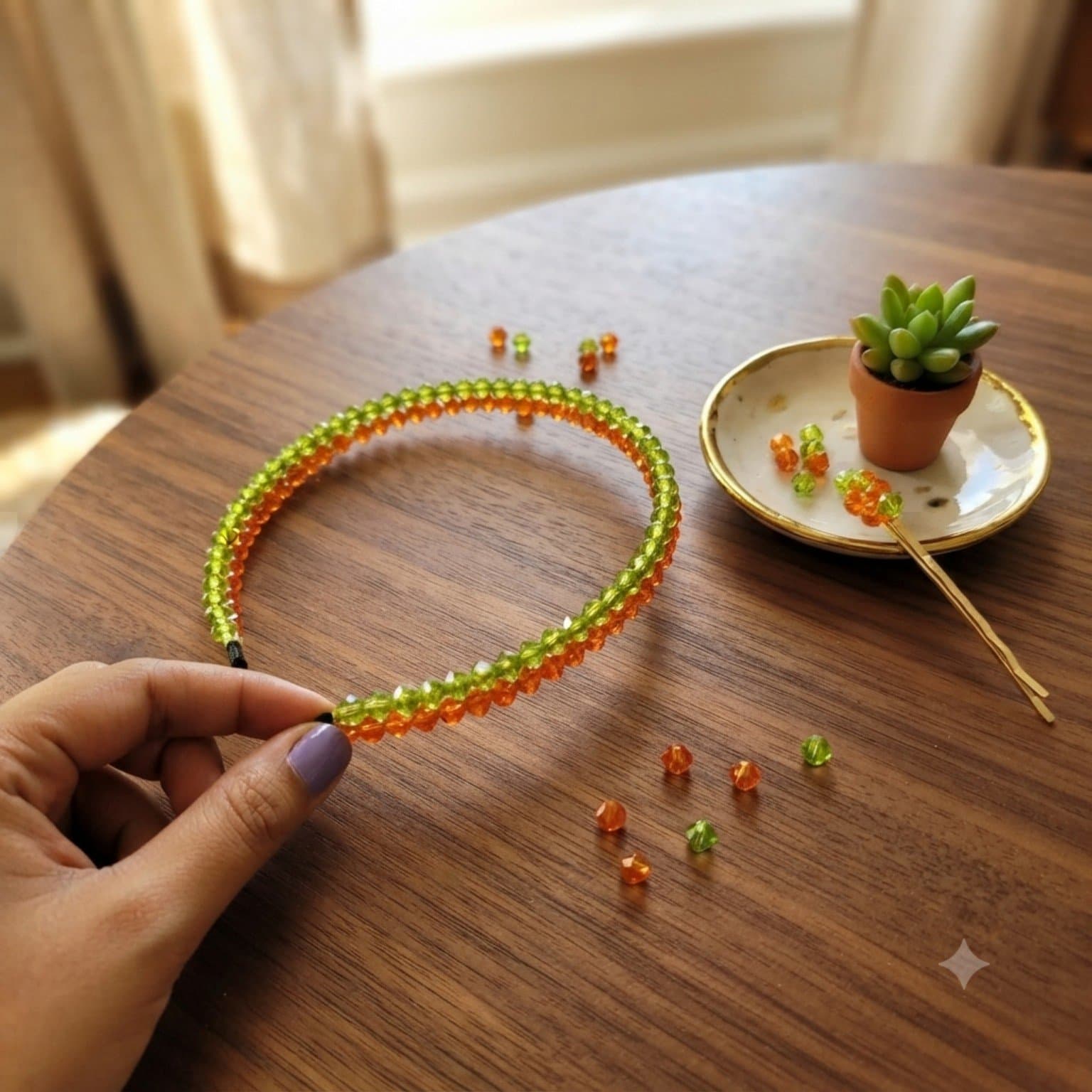 Green and orange faceted beaded headband displayed on a wooden table