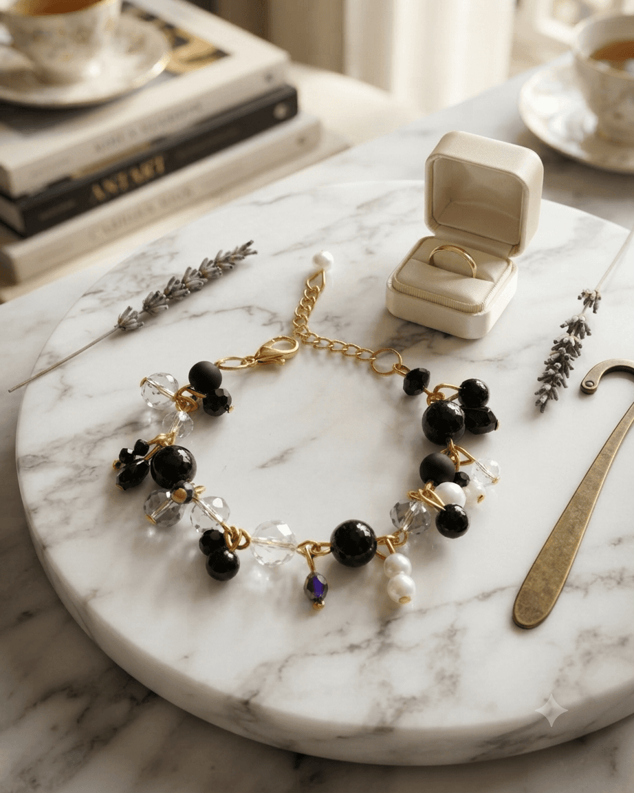 Handmade black and clear beaded chain bracelet with white and purple accent beads worn around a woman's wrist.