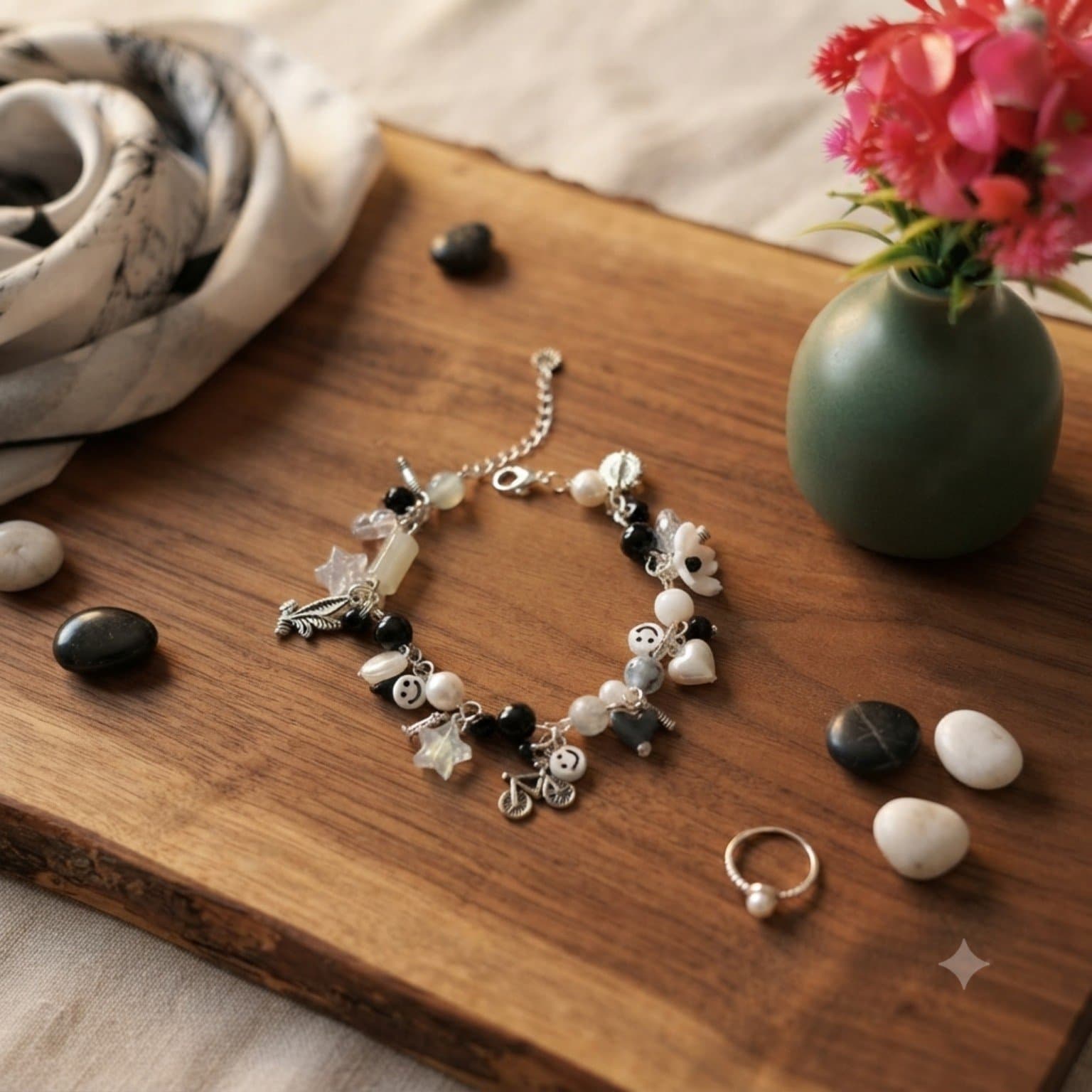 Handmade black and white beaded charm bracelet with smiley, heart, flower, star, leaf and bicycle-inspired decorative charms.