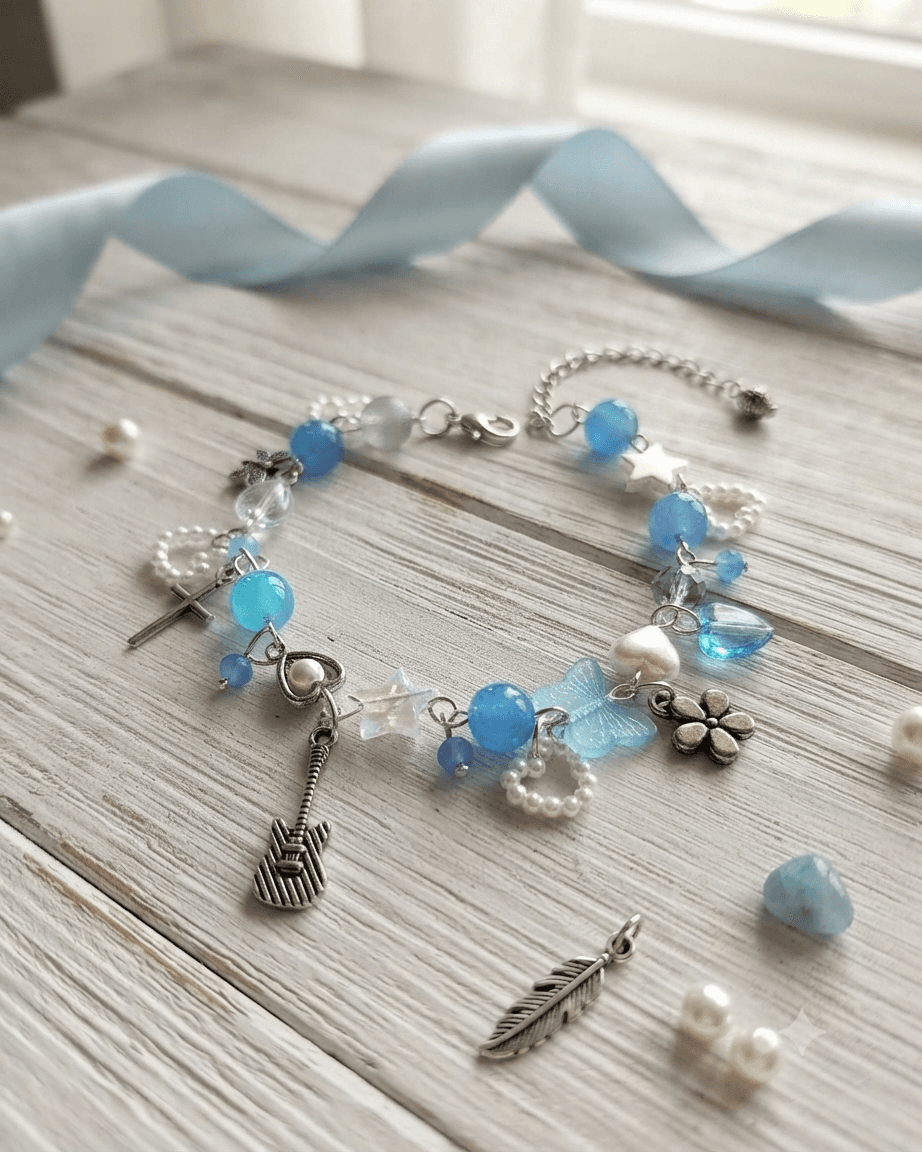 Handmade blue and white beaded charm bracelet with guitar, cross, butterfly, flower, heart and star details on a silver-tone chain.