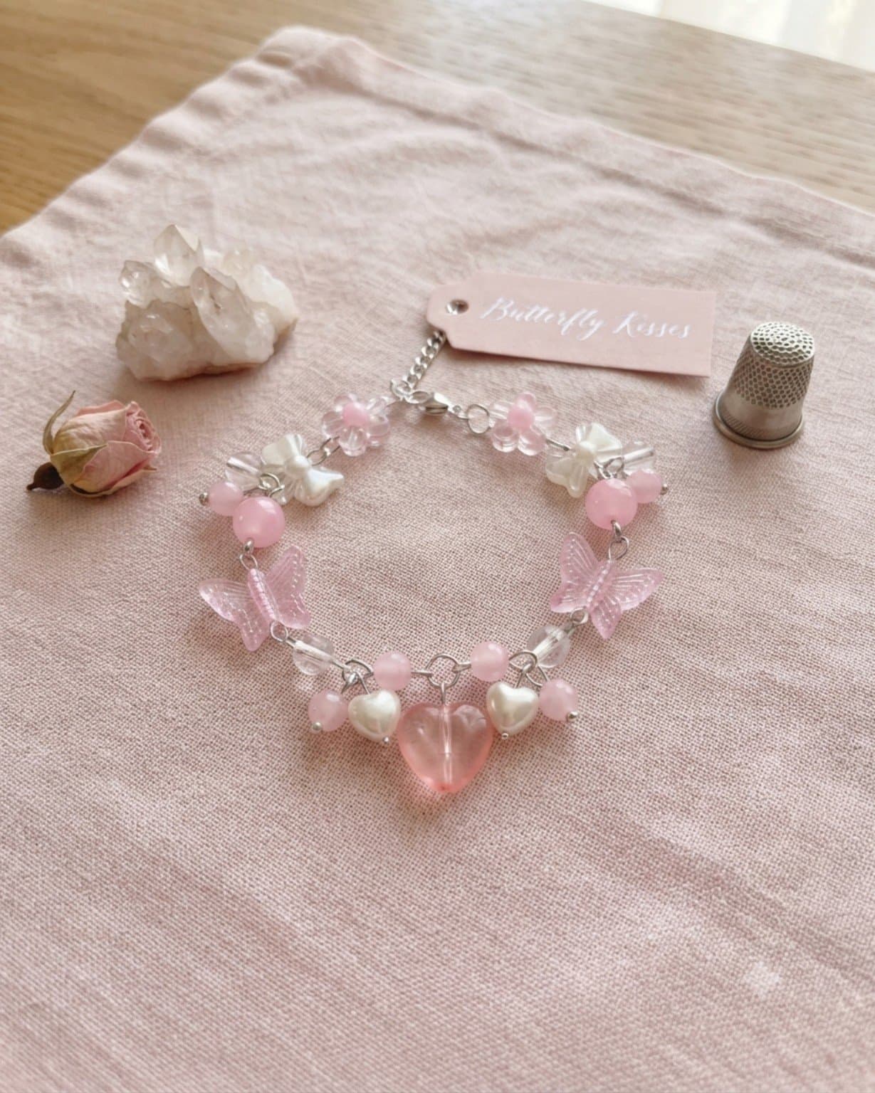 Handmade pink butterfly and heart charm bracelet with translucent pink butterfly beads, white heart details, clear accents and a large pink heart on a silver-tone chain.
