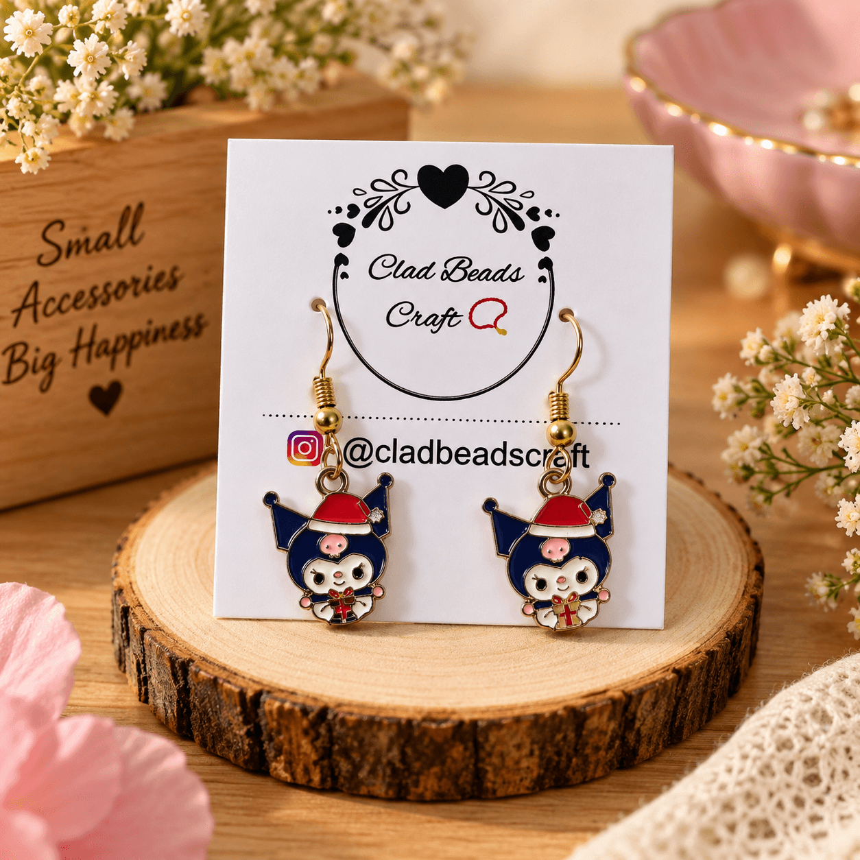 : Pair of navy blue, red, pink and white enamel-style charm earrings displayed on a Clad Beads Craft card.