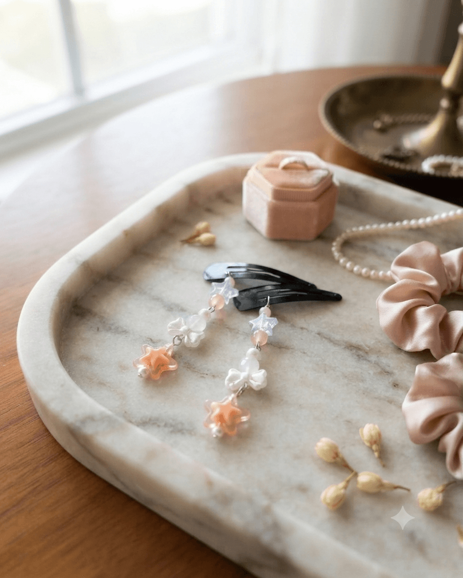 Pair of peach and lavender dangling beaded hair clips on a marble tray