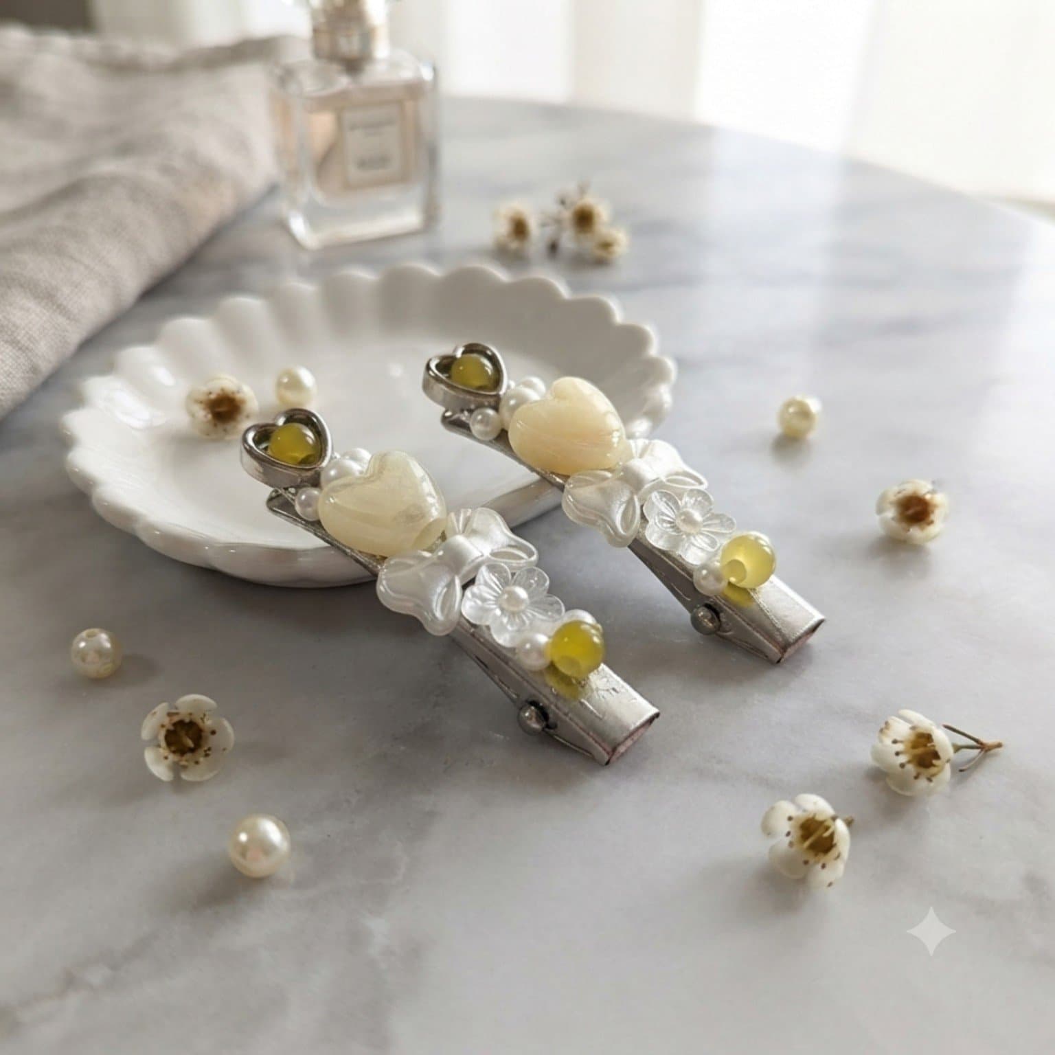 Pair of cream and yellow beaded hair clips with heart, flower, butterfly and pearl-look details